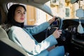 Portrait of happy female driver, beautiful confident Caucasian woman, steering car with safety belt. Driving concept Royalty Free Stock Photo