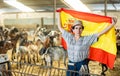 Portrait of happy female farmer with spanish flag in their hands in goat pen Royalty Free Stock Photo