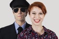 Portrait of happy female flight attendant and pilot against gray background