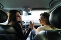 Portrait of happy female friends giving high five sitting in the car