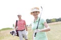 Portrait of happy female golfer with friend standing in background Royalty Free Stock Photo