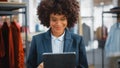 Portrait of a Happy Female Merchandising Manager Using Tablet Computer at a Stylish Clothing Store Royalty Free Stock Photo