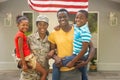 Portrait of happy female mid adult african american soldier with family outside house Royalty Free Stock Photo