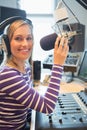 Portrait of happy female radio host broadcasting