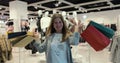 Portrait of a happy female smiling, dancing and spinning at clothing store with shopping bags. Young adult caucasian Royalty Free Stock Photo