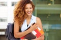 Happy female student smiling with bag and books on campus Royalty Free Stock Photo