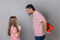 Father and daughter man hiding gift box behind his back, little girl waiting for her present. Royalty Free Stock Photo