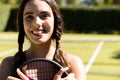 Portrait of happy fit caucasian woman holding tennis racket on outdoor tennis court, copy space Royalty Free Stock Photo