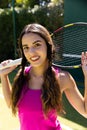 Portrait of happy fit caucasian woman holding tennis racket on sunny outdoor tennis court Royalty Free Stock Photo
