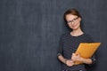 Portrait of happy friendly girl smiling and holding folder and pen Royalty Free Stock Photo