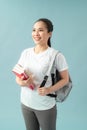 Portrait of a happy friendly girl student with backpack holding books  isolated over blue background Royalty Free Stock Photo