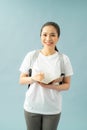 Portrait of a happy friendly girl student with backpack holding books  isolated over blue background Royalty Free Stock Photo