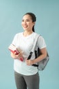 Portrait of a happy friendly girl student with backpack holding books  isolated over blue background Royalty Free Stock Photo