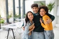 Portrait of happy friendly international college students embracing, posing in coworking space, free space