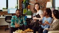 Portrait of happy friends having entertaining conversation, eating snacks from charcuterie board at home Royalty Free Stock Photo