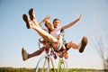 Portrait of happy, funny young active couple riding one bicycle. Lovely riders enjoying themselves. Romantic Royalty Free Stock Photo