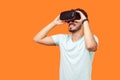 Portrait of happy gamer, brunette man playing virtual reality game. studio shot isolated on orange background Royalty Free Stock Photo