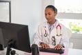 Portrait of happy general practitioner working at computer Royalty Free Stock Photo