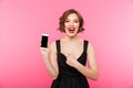 Portrait of a happy girl dressed in black dress pointing