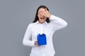 Portrait of a happy girl with gift box isolated over gray background. Woman holding gift present. Royalty Free Stock Photo