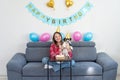 Portrait of a happy girl with her funny pet dog Jack Russell Terrier dog celebrating her birthday at home. Birthday cake and room Royalty Free Stock Photo