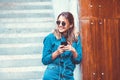 Portrait of a happy girl listening music on line with headphones from a smartphone in the street in a summer sunny day. Woman list Royalty Free Stock Photo