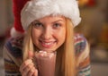 Portrait of happy girl in santa hat with cup of hot chocolate Royalty Free Stock Photo