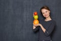 Portrait of happy girl smiling and holding colorful stack of fruits