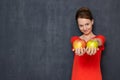 Portrait of happy girl smiling and offering to taste ripe apples Royalty Free Stock Photo