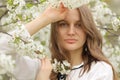 Portrait of a happy girl in spring flowers. A beautiful young girl with flowers bouquet near a floral wall Royalty Free Stock Photo