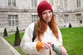 Portrait of happy girl traveler, drinking hot tea from thermos while walking and exploring city. Tourist with flask Royalty Free Stock Photo