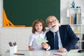 Portrait of happy grandfather and grandson hug, schoolboy pupil embrace teacher in classroom at school. Education in Royalty Free Stock Photo