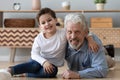 Portrait happy grandfather and little grandson sitting on warm floor Royalty Free Stock Photo