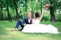 Happy groom and bride sitting in the lawn Royalty Free Stock Photo