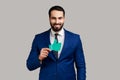 Handsome bearded businessman looking at camera with smile and showing paper thumb up. Royalty Free Stock Photo