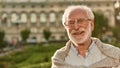 Portrait of happy and handsome bearded senior man in glasses looking at camera and smiling while spending time outdoors Royalty Free Stock Photo