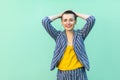 Portrait of happy handsome beautiful short hair young woman in casual striped suit standing, holding her head, looking at camera, Royalty Free Stock Photo