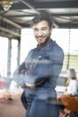 Portrait of happy businessman with arms crossed standing in office Royalty Free Stock Photo