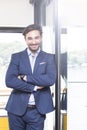 Portrait of happy businessman with arms crossed standing in office Royalty Free Stock Photo