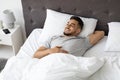 Portrait Of Happy Handsome Middle Eastern Guy Relaxing In Bed At Home