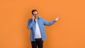 Portrait of happy handsome professional gesturing and talking over mobile phone on orange background Royalty Free Stock Photo