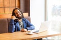 Portrait of happy handsome young adult man freelancer in casual style sitting in cafe with laptop, showing to make call him later Royalty Free Stock Photo