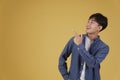 Portrait of happy handsome young asian man dressed casually pointing fingers at copyspace. yellow background Royalty Free Stock Photo