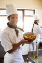 Portrait of happy head chef presenting his salad