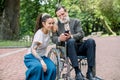 Portrait of happy hipster granddaughter with dreadlocks and barded grandfather in a wheelchair, having fun, making Royalty Free Stock Photo