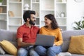 Portrait Of Happy Indian Couple With Laptop Relaxing On Couch At Home Royalty Free Stock Photo