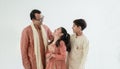 Portrait of happy Indian family standing over white background. Smart young father with little cute kids wearing traditional dress Royalty Free Stock Photo