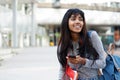 Happy Indian university student walking with mobile phone Royalty Free Stock Photo