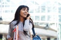 Happy Indian university student walking and talking with mobile phone Royalty Free Stock Photo