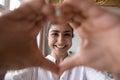 Portrait of happy Indian woman joins fingers showing love symbol